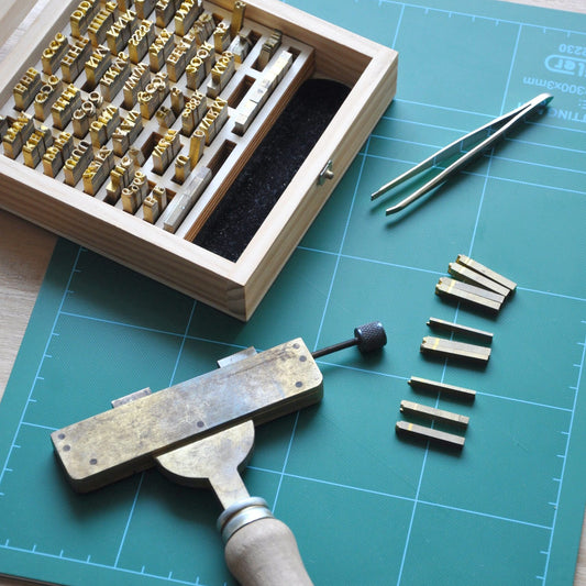 Hot-stamping tools: case of brass type, composing stick and tweezers